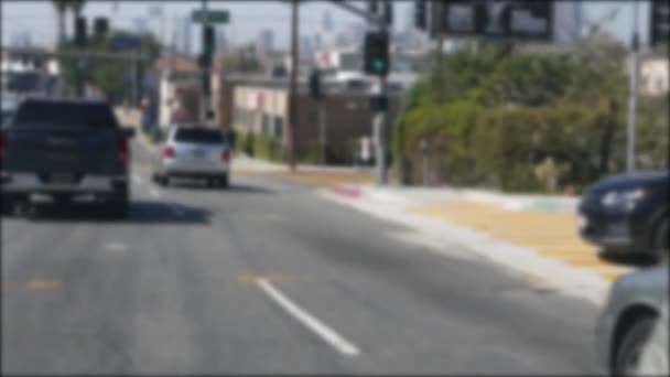 Vezetés Los Angeles belvárosi utcáin, Kalifornia USA. Defokted kilátás autó keresztül üveg szélvédő a kocsifelhajtón. Homályos út járművekkel Hollywoodban. Kamera belsejében auto, LA város esztétikai — Stock videók