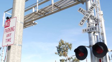 Amerika 'da seviye çapraz uyarı sinyali. Kaliforniya 'da demiryolu kavşağında çapraz ateş uyarısı ve kırmızı trafik ışığı. Demiryolu ulaşım güvenlik sembolü. Tehlike ve tren raylarıyla ilgili uyarı işareti.