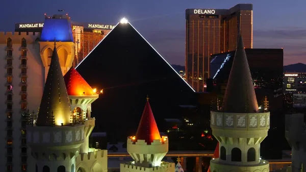 Лас -Вегас, штат Невада США - 4 березня 2020 р.: Замок Екскалібур та Піраміда Казино Піраміда незвичайного повітря. Літак летить з аеропорту МакКарран. Готель Mandalay Bay та Dlano в американському місті азартних ігор. Ліцензовані запасні зображення