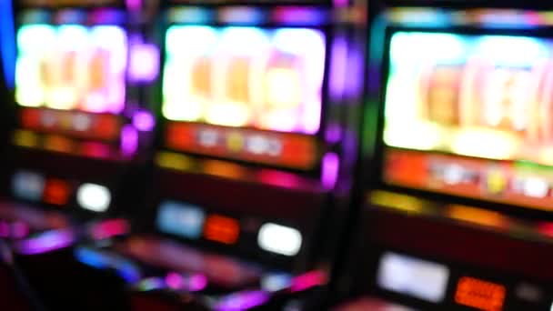 Defocused slot machines glow in casino on fabulous Las Vegas Strip, USA. Blurred gambling jackpot slots in hotel near Fremont street. Illuminated neon fruit machine for risk money playing and betting — Stock Video