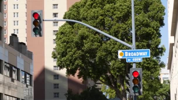 Broadway gadenavn, odonym tegn og trafiklys på søjle i USA. Vejkryds i centrum af byen. Crossroad i det centrale erhvervskvarter. Navneskilt banner med titel af vigtigste avenue – Stock-video