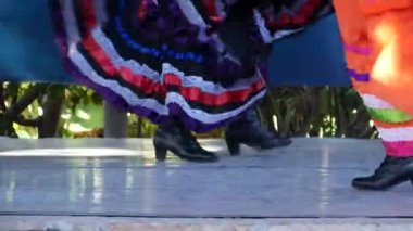 Renkli geleneksel elbiseli Latin kadınlar dans ediyorlar Jarabe Tapatio, Meksika halk şapkası dansı. Çok renkli etnik etek giymiş İspanyol kadın balesinin sokak performansı. Kostümlü kızlar