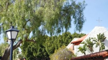 Meksika sömürgesi tarzı banliyö, İspanyol evi dışı, yeşil yemyeşil yemyeşil bahçe, San Diego, Kaliforniya ABD. Akdeniz terasotta seramik kil kiremit çatıda. Kırsal ispanyolca döşeli çatı. Kırsal ayrıntı