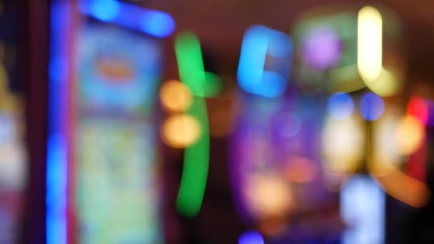 Defocused slot machines glow in casino on fabulous Las Vegas Strip, USA. Blurred gambling jackpot slots in hotel near Fremont street. Illuminated neon fruit machine for risk money playing and betting — Stock Video