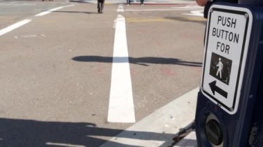 Yaya geçidinde trafik ışığı düğmesi, insanlar itmek ve beklemek zorunda. ABD 'de halkın güvenliği için trafik kuralları ve yönetmelikleri. Zebra caddesi San Diego, Kaliforniya 'da yol ayrımında kesişiyor.