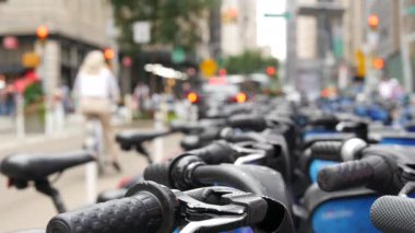 New York City Manhattan şehir merkezi caddesi ya da Midtown Bulvarı kavşağı. ABD 'de şehir trafiği. Birleşik Devletler 'deki yayaların dikkatini dağıttı. Mavi kiralık bisikletler, ortak bisiklet istasyonu..