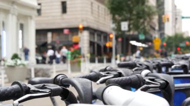 New York City Manhattan şehir merkezi caddesi ya da Midtown Bulvarı kavşağı. ABD 'de şehir trafiği. Birleşik Devletler 'deki yayaların dikkatini dağıttı. Mavi kiralık bisikletler, ortak bisiklet istasyonu..