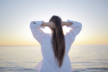 Genç kadın denizde, geri görünüm, özgürlük ve mutluluk kavramı arıyor