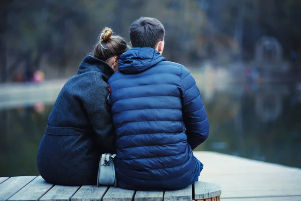 年轻的男人和女人坐在板凳上在冬季公园 浪漫愉快的情侣 — 图库照片