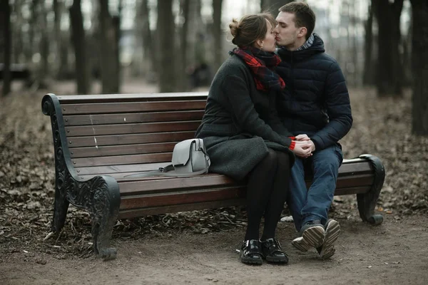 冬の公園 ロマンチックな幸せなカップルで一緒にベンチに座っている若い男女 — ストック写真