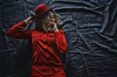 kırmızı elbiseler ve kırmızı şapka giyen çekici genç sarışın kadın  