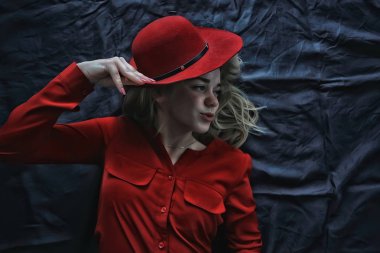 kırmızı elbiseler ve kırmızı şapka giyen çekici genç sarışın kadın  