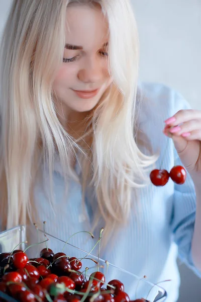 新鮮なサクランボを食べるかわいい若いブロンドの女性 — ストック写真