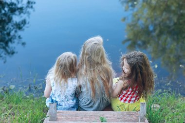 nehir üzerinde üç sevimli küçük kız. Yaz tatili. Tatil, kız nehir, dostluk, mutluluk ve aile üzerinde birlikte mutlu kız