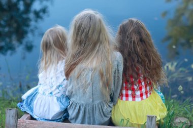 nehir üzerinde üç sevimli küçük kız. Yaz tatili. Tatil, kız nehir, dostluk, mutluluk ve aile üzerinde birlikte mutlu kız