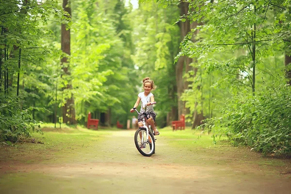 在避暑公园骑自行车的小女孩 — 图库照片