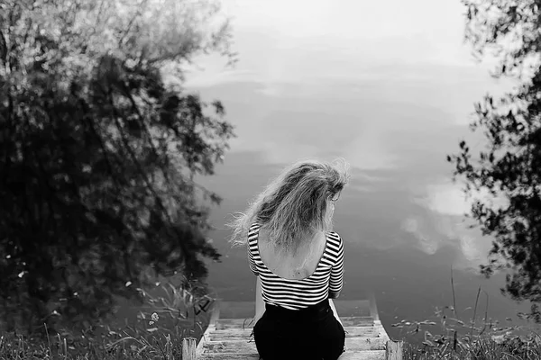 美丽的悲伤的女人坐在河岸上 — 图库照片