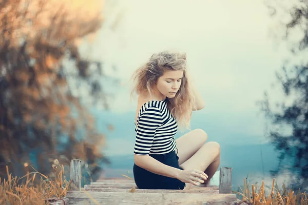 川岸に座っている悲しい美人 — ストック写真
