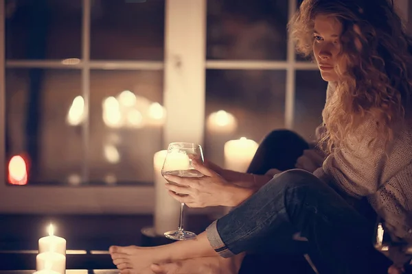 romantic woman with candles in cozy house