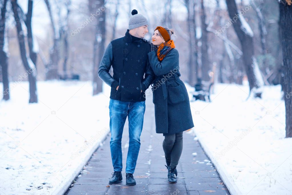 young man and woman hugging in winter park, romantic happy couple 