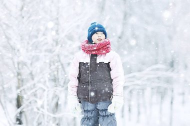 sevimli küçük kız parkta karlı kış, sıcak giysiler içinde bir çocuğun mevsimlik fotoğraf