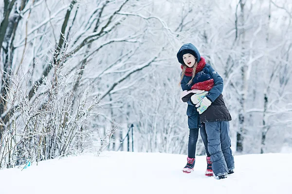 冬の公園で雪と遊ぶ二人の少女 子供の頃 家族の概念 — ストック写真