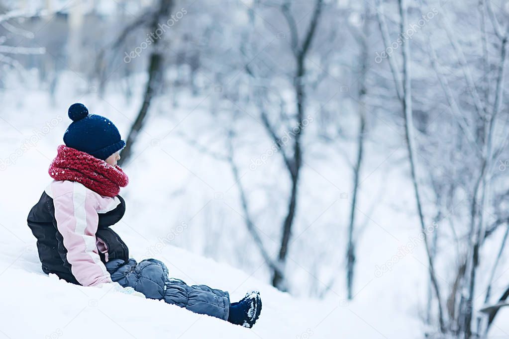 cute little girl in snowy winter park, seasonal photo of a child in warm clothes