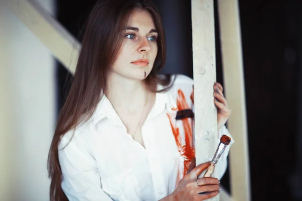 年轻漂亮的女性艺术家 用油漆刷在车间 — 图库照片