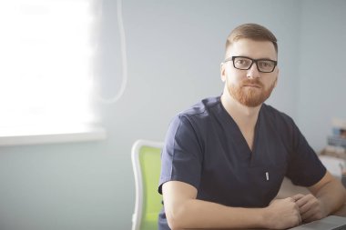 kendine güvenen erkek doktor kliniğinde tıbbi üniformalı 