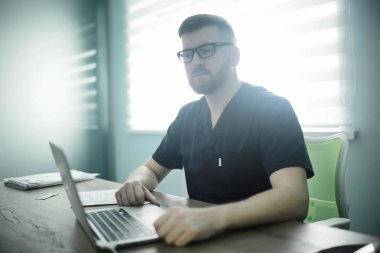 kendine güvenen erkek doktor kliniğinde tıbbi üniformalı 