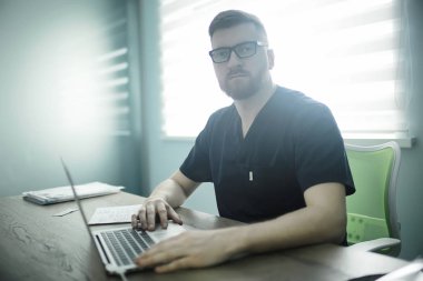 kendine güvenen erkek doktor kliniğinde tıbbi üniformalı 