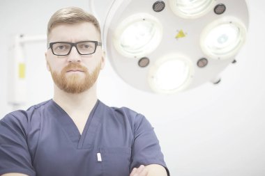 arka plan, tıp ve cerrahi kavramı kendine güvenen erkek cerrah poz tıbbi üniformalı bulanık