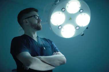 arka plan, tıp ve cerrahi kavramı kendine güvenen erkek cerrah poz tıbbi üniformalı bulanık