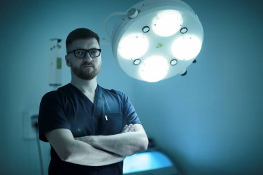 arka plan, tıp ve cerrahi kavramı kendine güvenen erkek cerrah poz tıbbi üniformalı bulanık