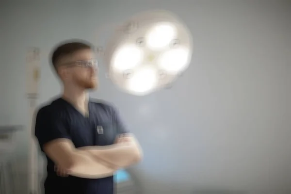 confident male surgeon in medical uniform posing on blurred background , concept of medicine and surgery