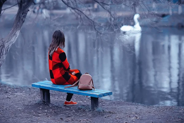 年轻的褐发女郎妇女放松附近一个湖坐在长椅上 秋季景观 — 图库照片