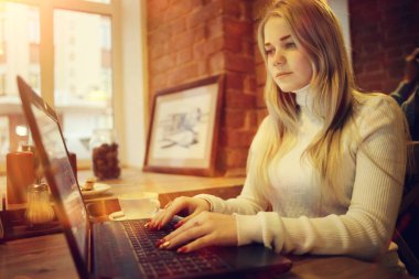 Kafe, uzaktan çalışma, eğitim, sınavlar için Restoran Gadget'ta kızla hazırlanıyor öğrenci kavramı içinde laptop üzerinde çalışan genç kadın