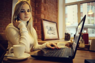 Kafe, uzaktan çalışma, eğitim, sınavlar için Restoran Gadget'ta kızla hazırlanıyor öğrenci kavramı içinde laptop üzerinde çalışan genç kadın