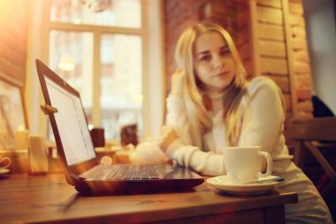 Kafe, uzaktan çalışma, eğitim, sınavlar için Restoran Gadget'ta kızla hazırlanıyor öğrenci kavramı içinde laptop üzerinde çalışan genç kadın