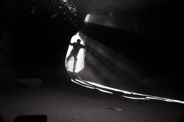 Wejście Jaskini Mężczyzna Podróżnik Stoi Promienie Światła Przy Wyjściu Jaskini — Zdjęcie stockowe
