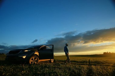 gün batımı, zam, Aktif istirahat kavramı, yeşil çim üzerinde sırt çantası ile acımasız adam