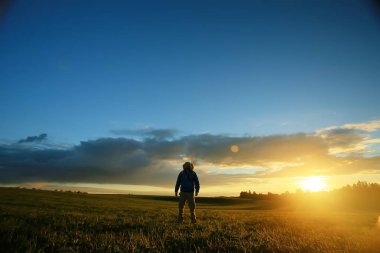 gün batımı, zam, Aktif istirahat kavramı, yeşil çim üzerinde sırt çantası ile acımasız adam