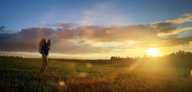 gün batımı, zam, Aktif istirahat kavramı, yeşil çim üzerinde sırt çantası ile acımasız adam