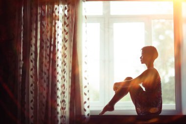 bir pencere üzerinde evde oturan rüya gibi genç kadın portresi