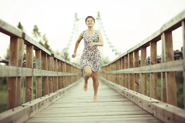 木造の橋 素朴なスタイルの短い夏のドレスの若い美しい女性の肖像画 — ストック写真