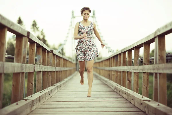 年轻漂亮的女人 在短暂的夏季衣服上木桥 乡村风格的肖像 — 图库照片