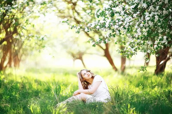 春の庭のリンゴの木花と若い美しい女性の肖像画 — ストック写真