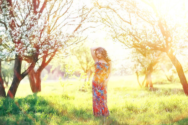 Portrait of young beautiful woman with apple tree blossom in spring garden