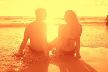 Sahilde, mutlu insanlar rahatlatıcı deniz kenarında güneşlenirken arkadaş grubu