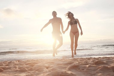 aşık kumlu plaj, Genç adam ve kadın denizde rahatlatıcı sahil, yaz tatili kavramı, denizde tatil